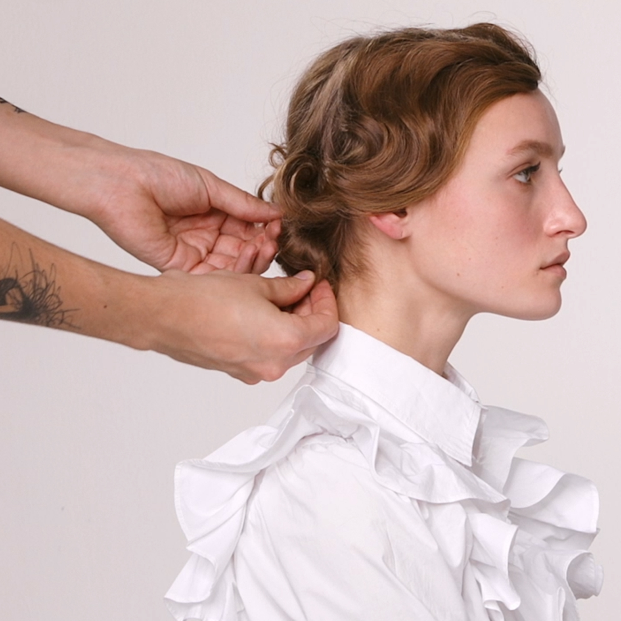 Hårstylist sætter modellens hår op