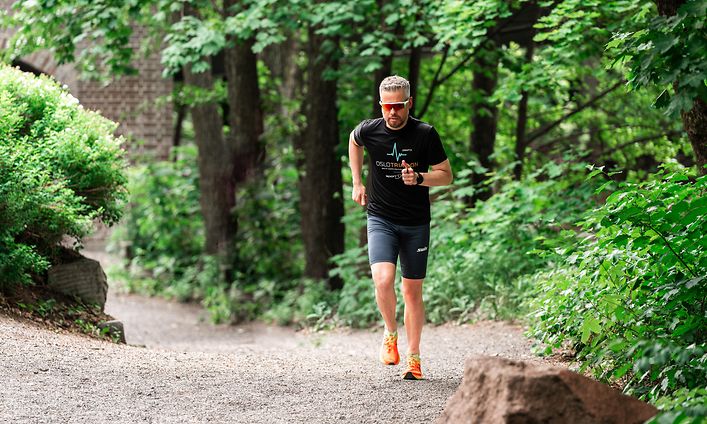 Mand der løber med et sportswatch og solbriller
